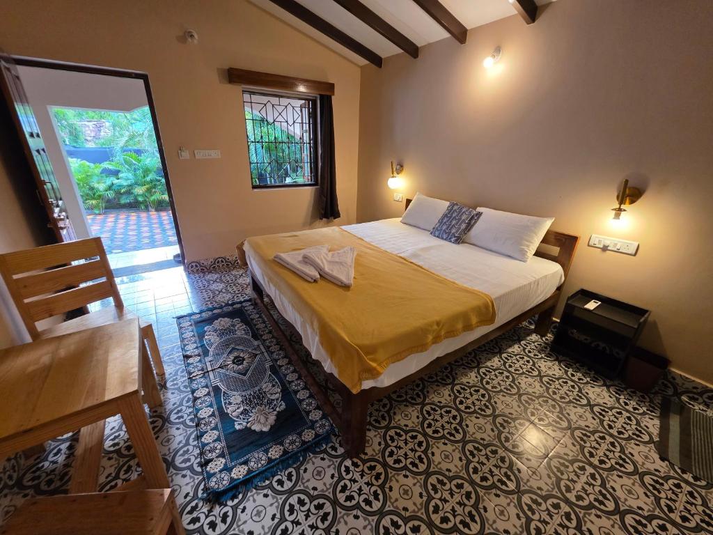 a bedroom with a bed and a door to a patio at Joe Banana Stays in Anjuna