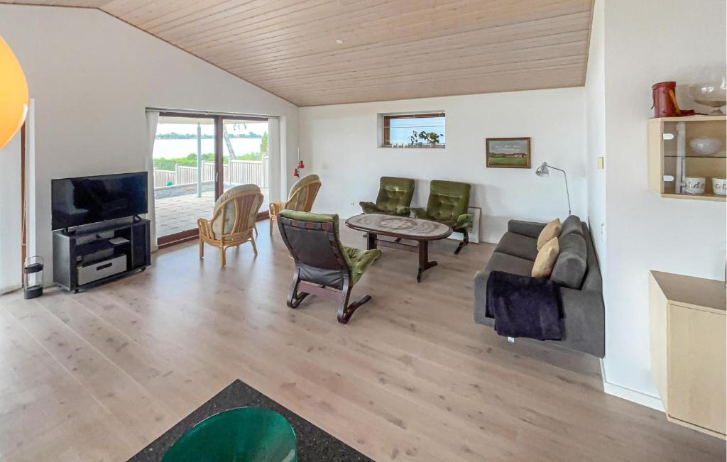 Una sala de estar con un sofá y un televisor. en Lovely Home In Sunds With House Sea View, en Sunds