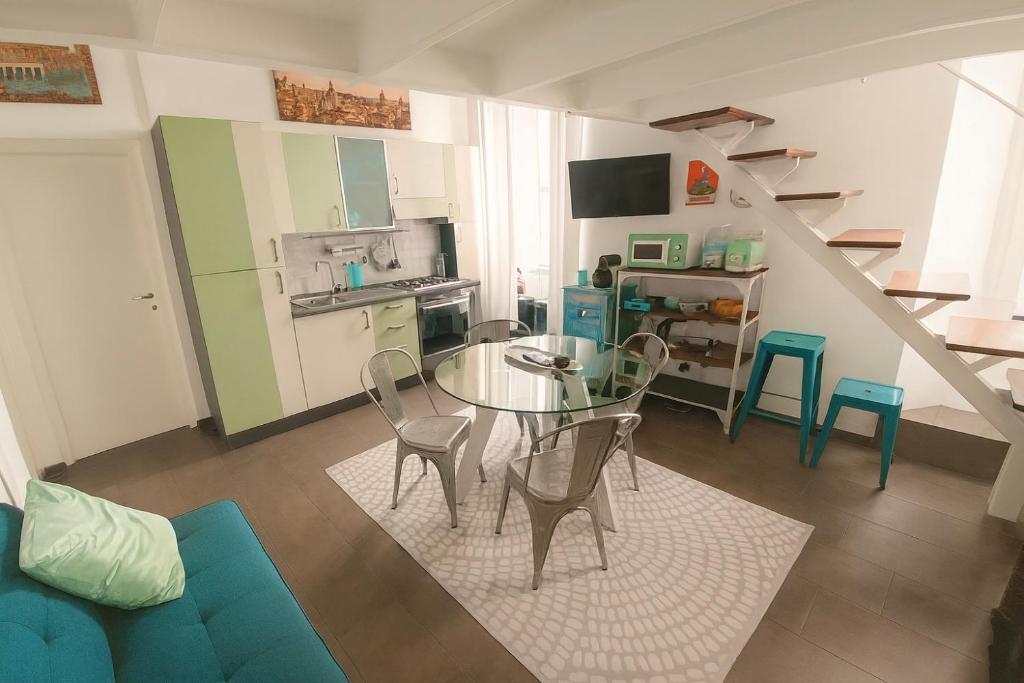 Una sala de estar con mesa y sillas y una cocina. en Trastevere Stars, en Roma