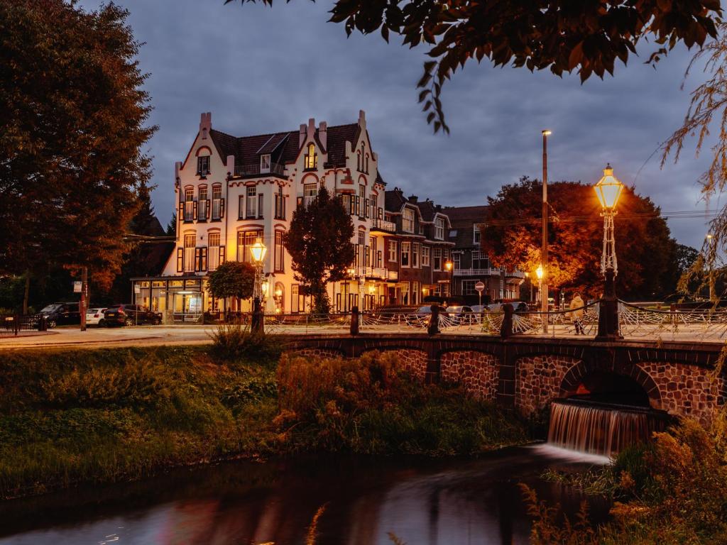a large building with a bridge over a river at Hotel Molendal in Arnhem