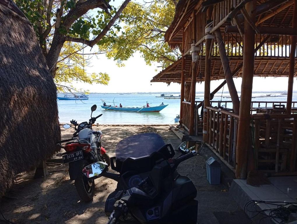 a motorcycle parked next to a building next to the water at Sunset Cabanas Stay Beachfront & Snorkel 
