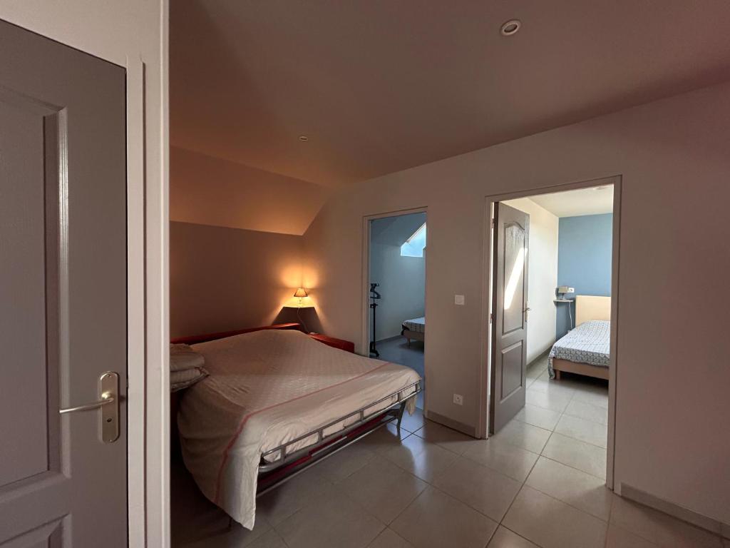 a bedroom with a bed and a door leading to a bedroom at MAISON DE VACANCES AVEC PISCINE INTERIEURE - Le Grand Champagne in Saint-Victeur