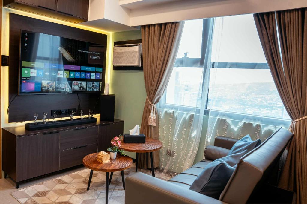 a living room with a couch and a large window at LM50L2 horizon101 cebu in Cebu City
