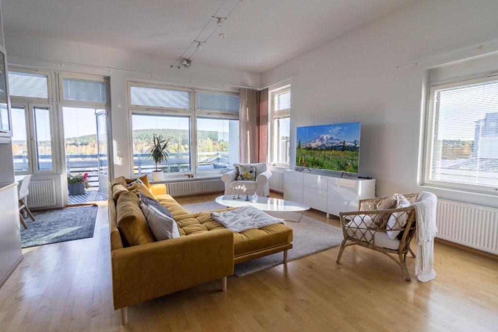 a living room with a couch and a table at Big river view city apartment in Rovaniemi