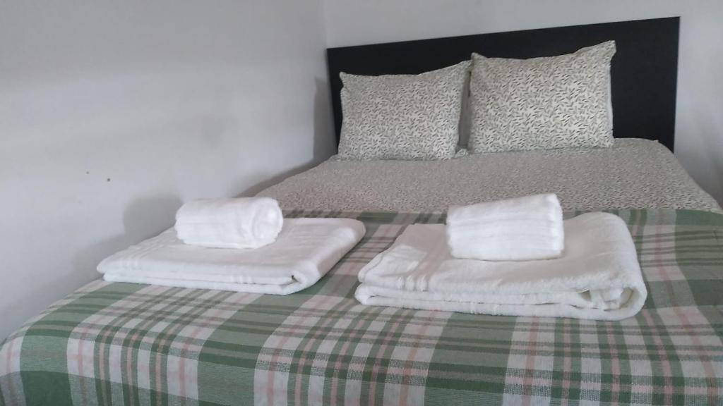 a bed with two white towels on top of it at Ranjeet felizarda in Lisbon