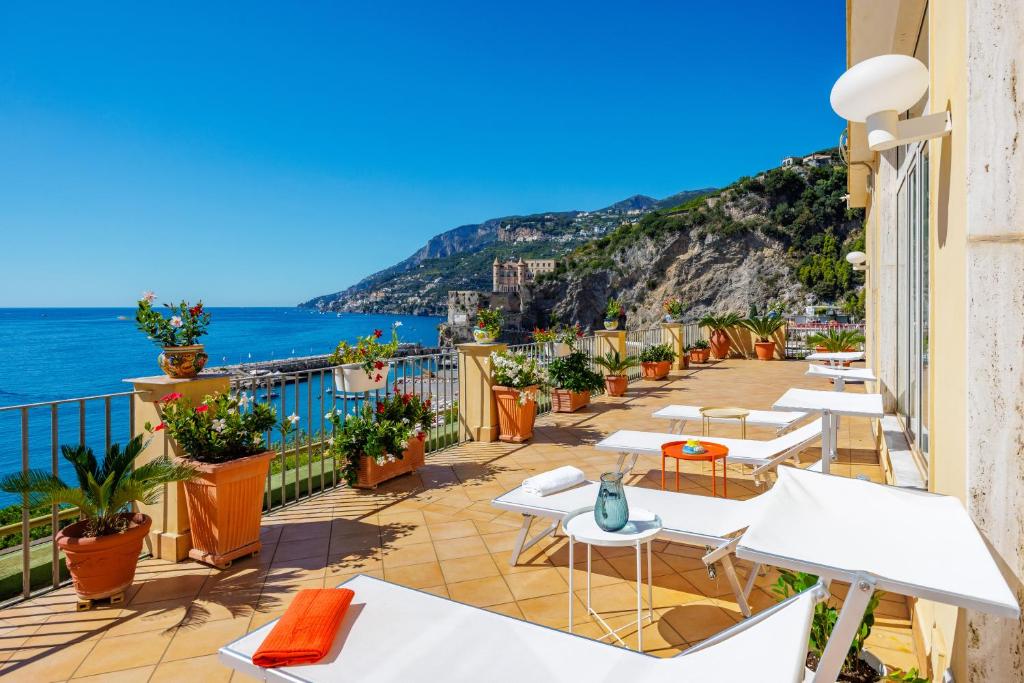 a balcony with tables and chairs and the ocean at Residence Panoramic in Maiori