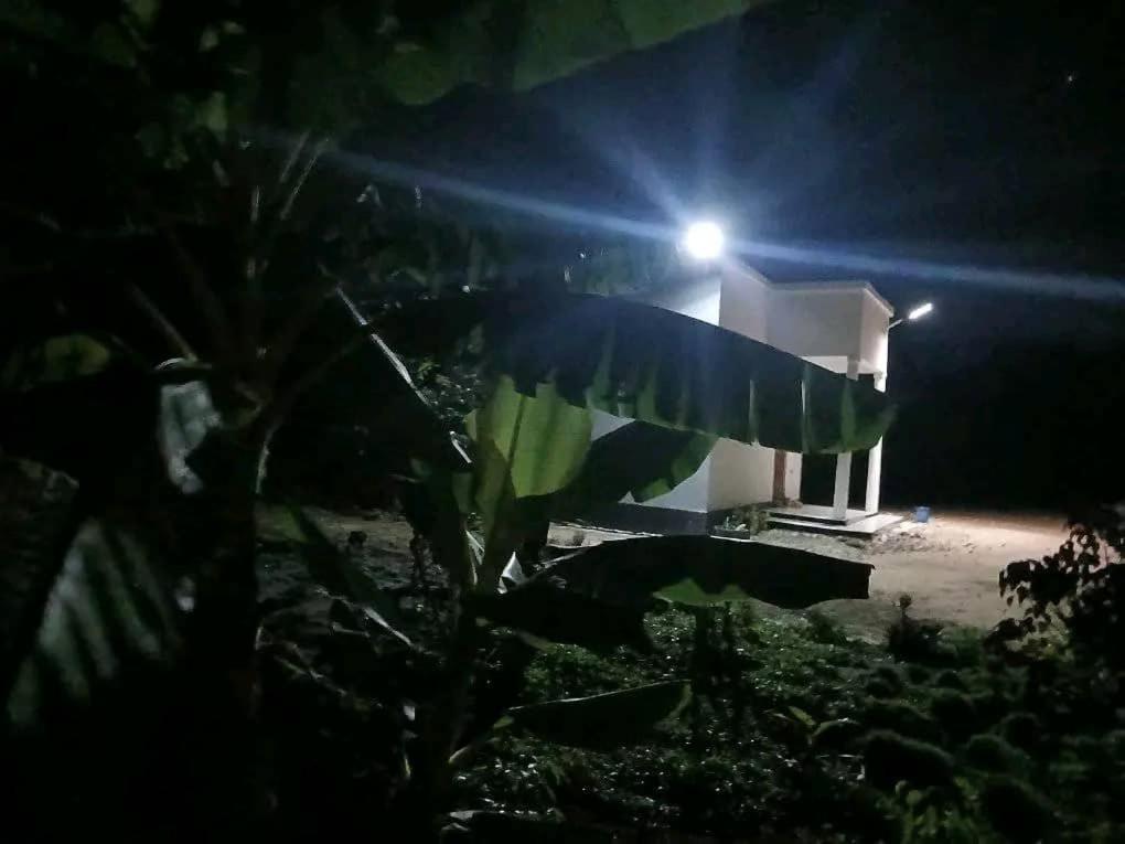 a house at night with a light in the background at Makucha Ya Simba Homestay and camping grounds in mwanza in Mwanza
