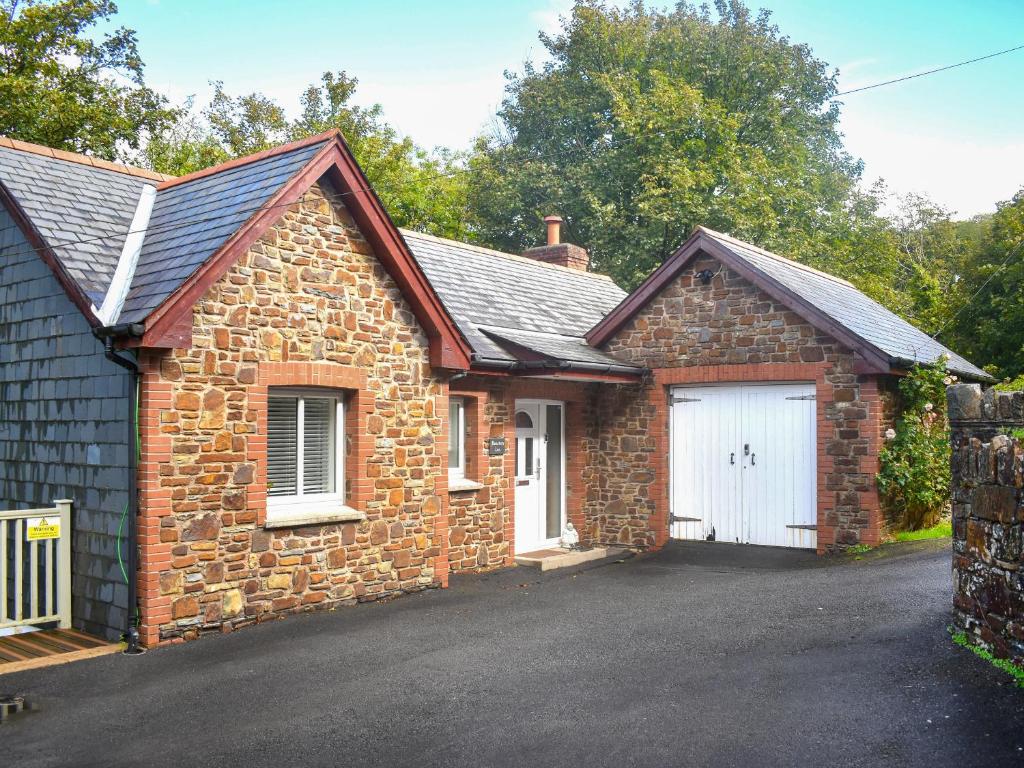 una casa de ladrillo con garaje blanco en Bracken Lea, en Barbrook