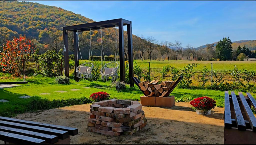 a park with benches and a fire pit and a gazebo at Guest House Gacka Rogić in Otočac