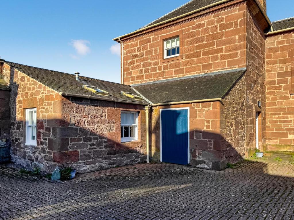 Un edificio de ladrillo con una puerta azul. en The Old Bakery - Uk48319, en Berwick-Upon-Tweed