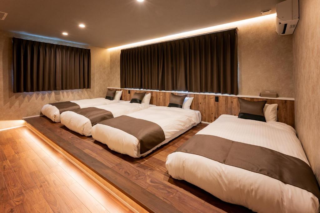 a room with three beds in a room at Sky deck for rent! Fuji view Open-air bath New building in Fujiyoshida