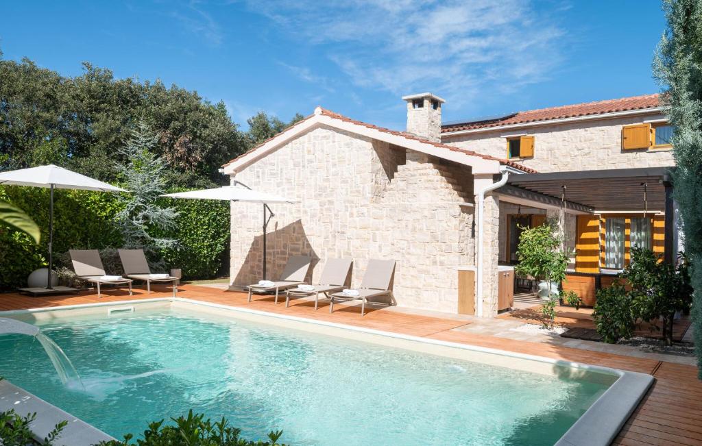 Una piscina con sillas y sombrillas al lado de una casa. en Villa Paula, en Ugljan
