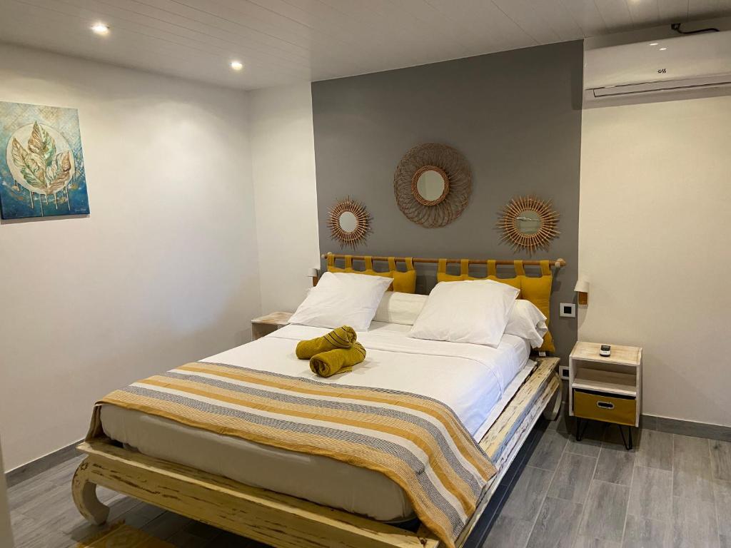 a teddy bear laying on a bed in a bedroom at Le belair in Le Diamant
