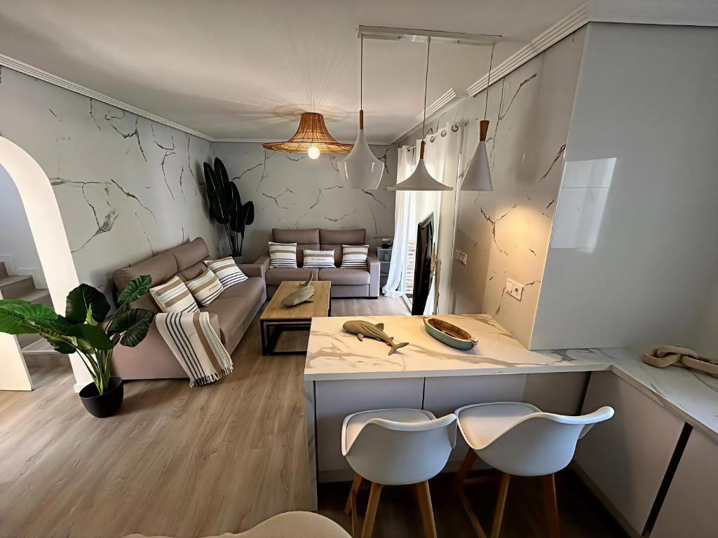 ein Wohnzimmer mit einer Couch und einem Tisch und Stühlen in der Unterkunft ThE WHALE HOUSE in El Campello