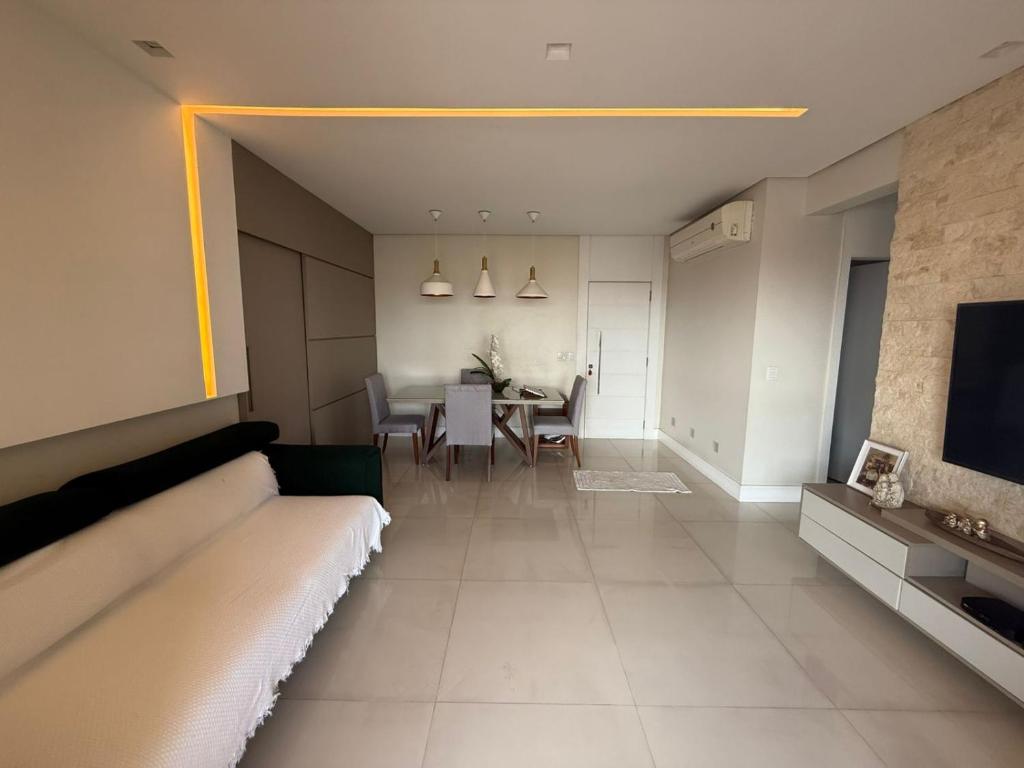 a living room with a couch and a dining room at Apartamento 03 suítes in Belém