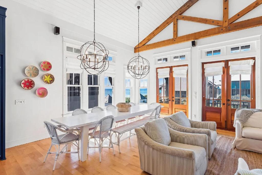 a dining room with a white table and chairs at Luxurious Four Bedroom Beach Home with Gulf Views in Rosemary Beach