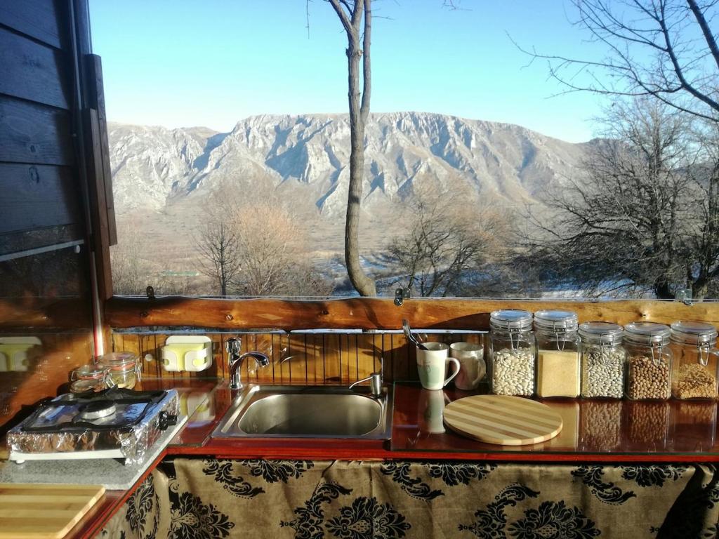 cocina con fregadero y vistas a la montaña en Remote Tiny House Retreat, en Rimetea