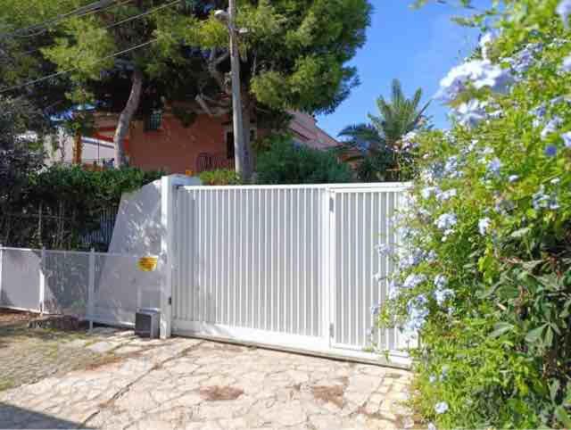 a white fence in front of a house at Mariella domus intero appartamento in bifamiliare in San Vito