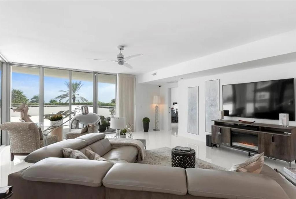 a living room with a large couch and a tv at Southeast Oceanfront Residence in Hollywood Beach
