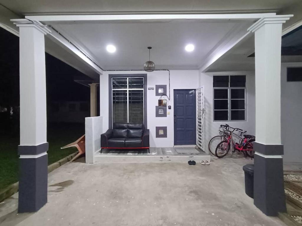 una sala de estar con una puerta azul y una silla en ABE Homestay Gong Badak, en Kuala Terengganu
