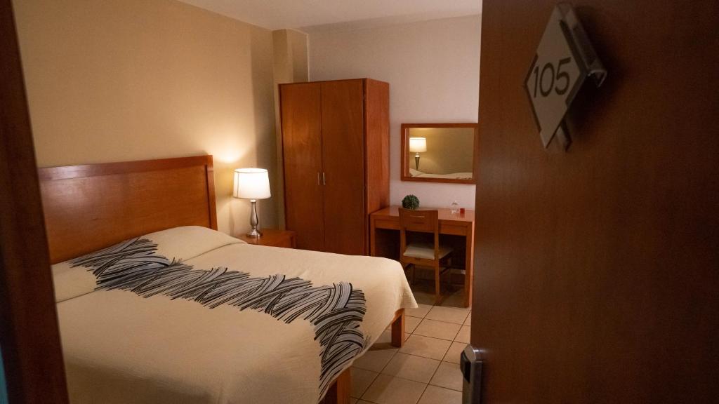 una habitación de hotel con una cama y un escritorio en Hotel Marllou, en Xalapa