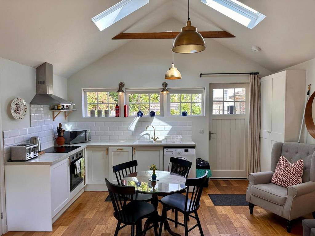 eine Küche und ein Wohnzimmer mit Tisch und Stühlen in der Unterkunft The Cottage in Bristol