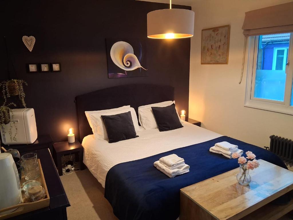 a bedroom with a bed with a blue blanket at Super king bedroom with large ensuite in Brighton & Hove