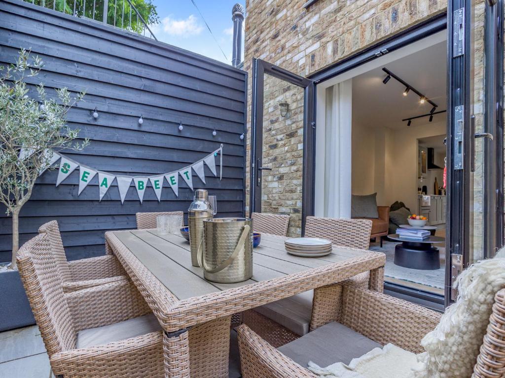 a patio with a table and chairs and a building at Sea Beet - Uk49245 in Whitstable