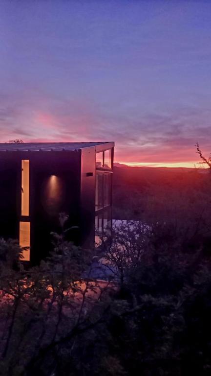 a building with the sunset in the background at Cubos habitables 3 in San Antonio de Arredondo
