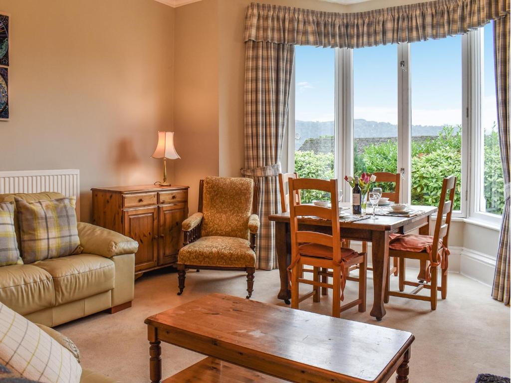 Una sala de estar con una mesa y sillas y un sofá. en Lakeland Villa, en Bowness-on-Windermere