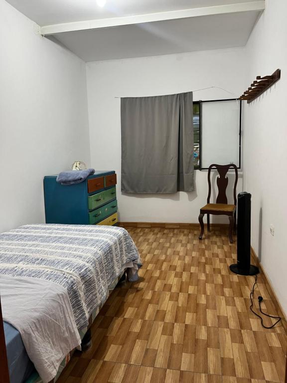 Un dormitorio con una cama y una cómoda y una ventana. en Cozy house near beaches, en Caleta Cruz
