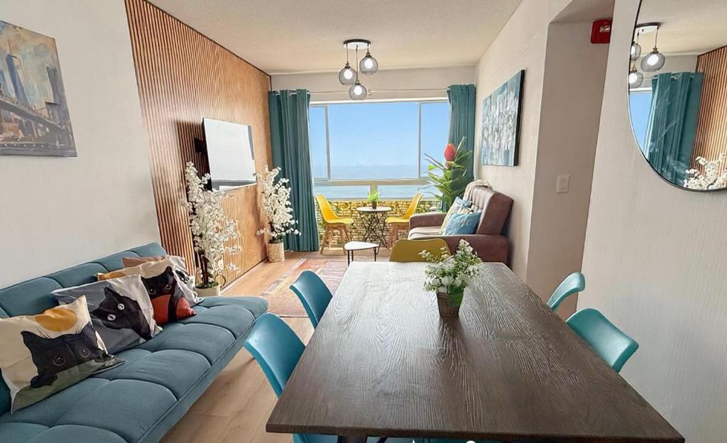 a living room with a table and a blue couch at Nuevo exclusivo con vista al mar - Blue One in Lima