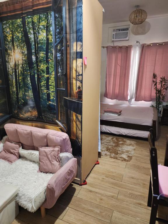 una sala de estar con un sofá y una cama en Condotel Near NAIA - massage chair footspa, dance revo, small pet allowed, en Manila