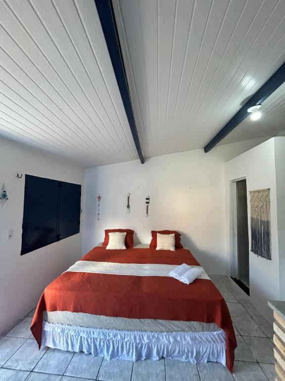 a bedroom with a large red bed in a room at Suítes Canoa Azul in Aracati