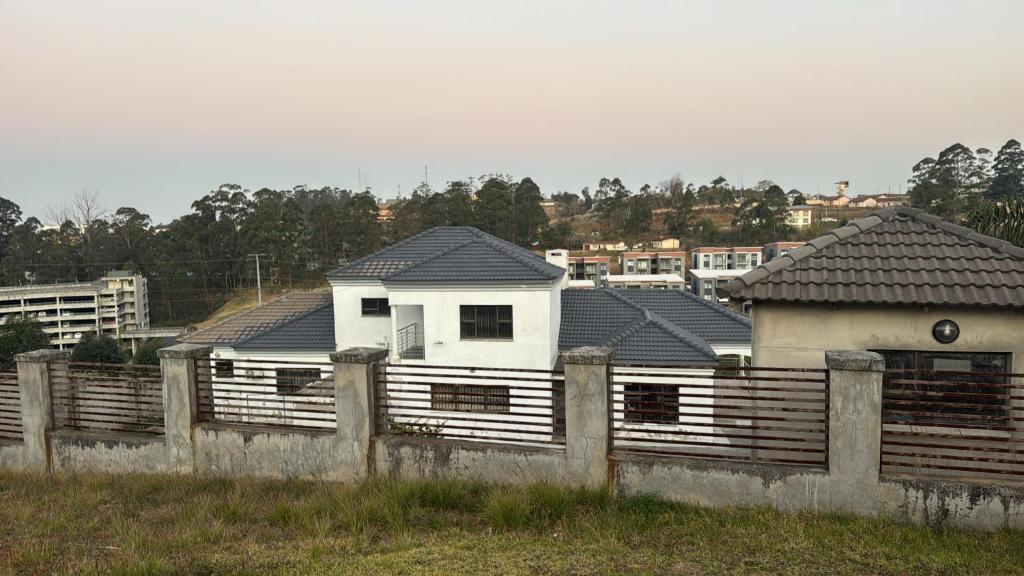 a row of houses behind a wooden fence at Cozy Central BNB in Mbabane