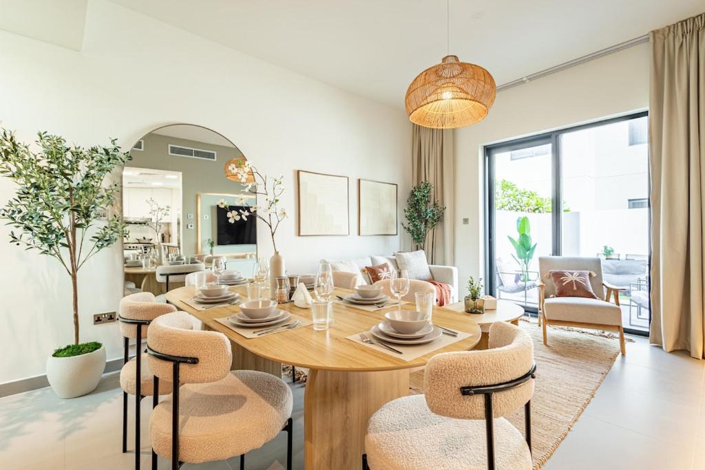 ein Esszimmer und ein Wohnzimmer mit Tisch und Stühlen in der Unterkunft Amazing Townhouse - Yas Island - 5 min to Formula 1, Ferrari World, Warner Bros, Sea World - Designer's Choice in Abu Dhabi