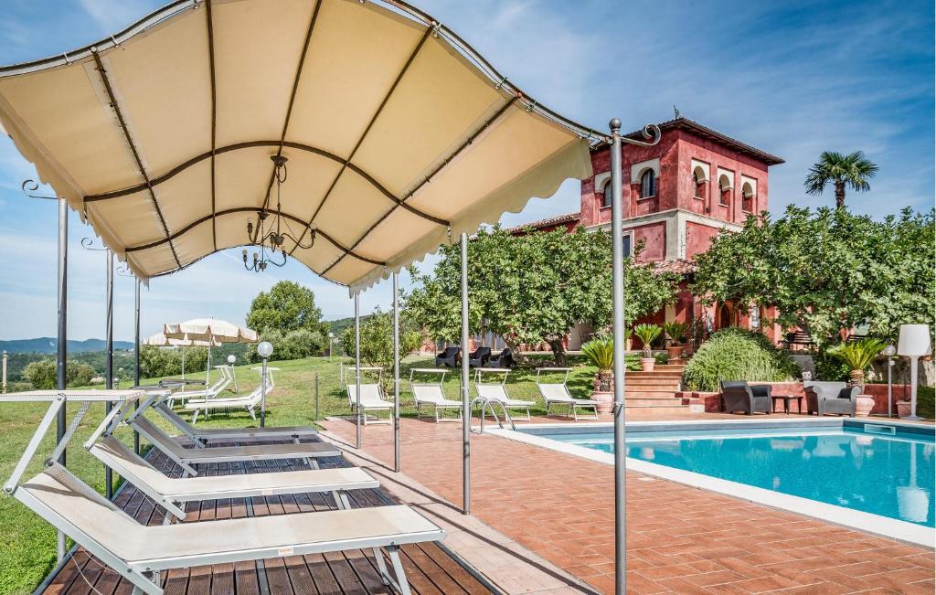 an outdoor swimming pool with a large umbrella at Gorgeous Home In Rivodutri in Apoleggia