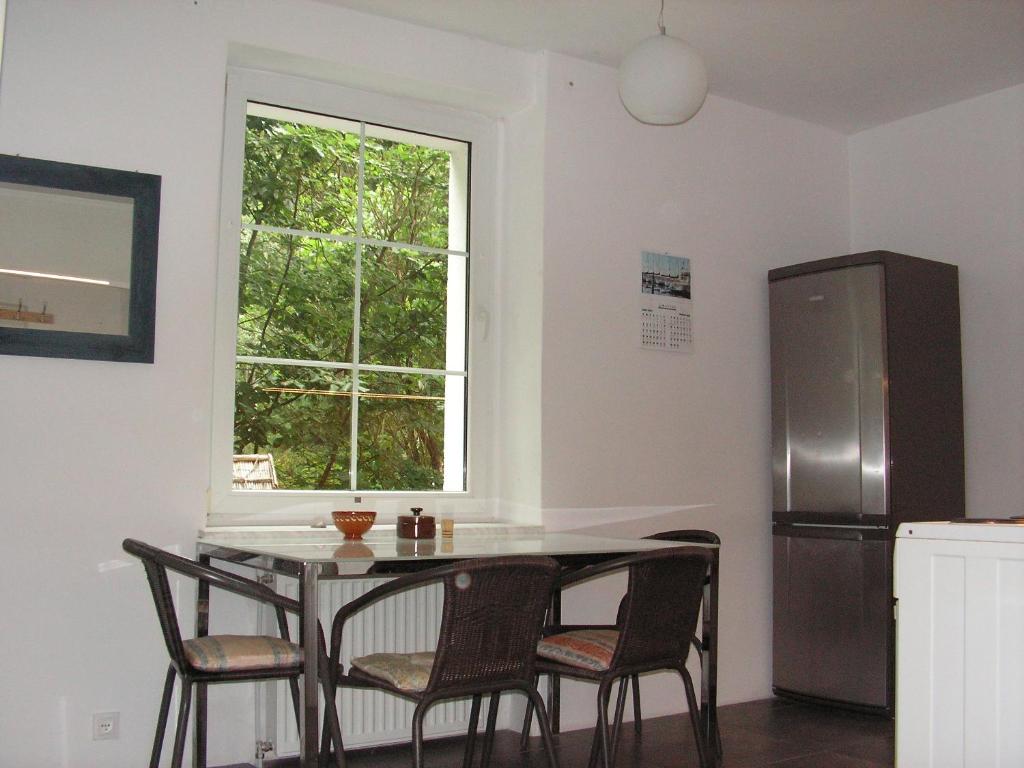 cocina con mesa, sillas y ventana en Apartament Moonlight, en Sopot