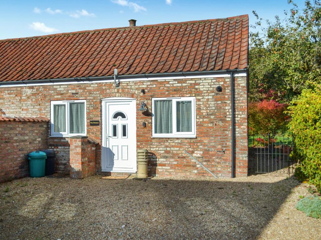 a brick house with a white door and window at The Pottery in Horncastle