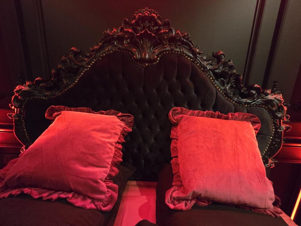a bed with a red headboard and two red pillows at Elisabeta Suite - Eternal Romance with Balneo XL in Chamalières