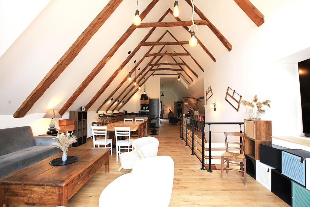 a living room with wooden tables and chairs at Le Petit Nid de Gioux in Rochefort-Montagne