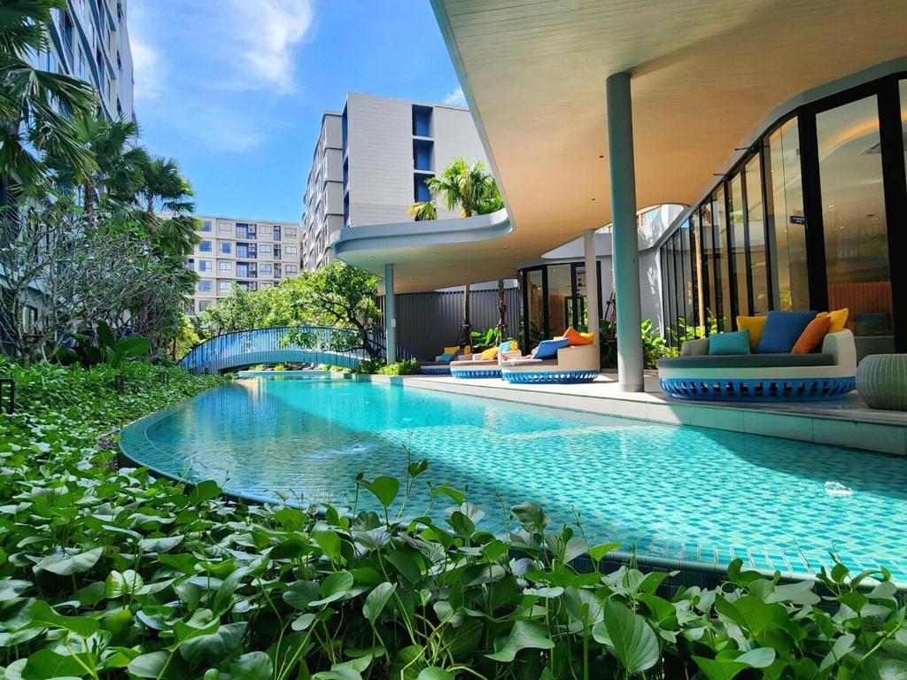a swimming pool in front of a building at Cozy Minimalist apartment in Kathu