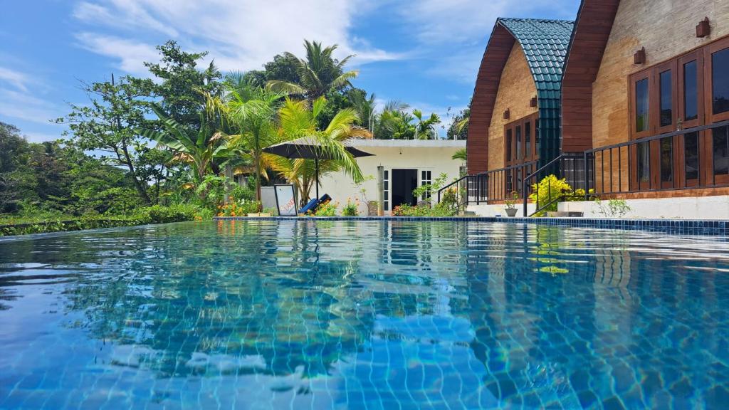 een zwembad voor een huis bij Maggona Boutique Cottages in Maggona West