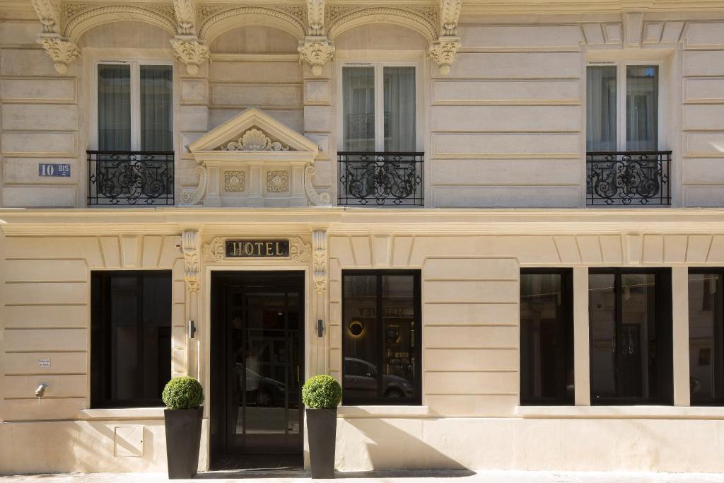 un bâtiment avec un panneau d'hôtel devant lui dans l'établissement Hotel Le 10 BIS, à Paris