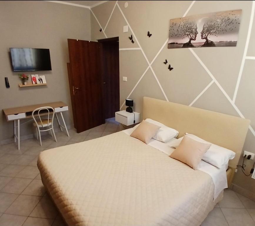 a bedroom with a bed and a desk and a television at Marruvium 1937's in Avezzano