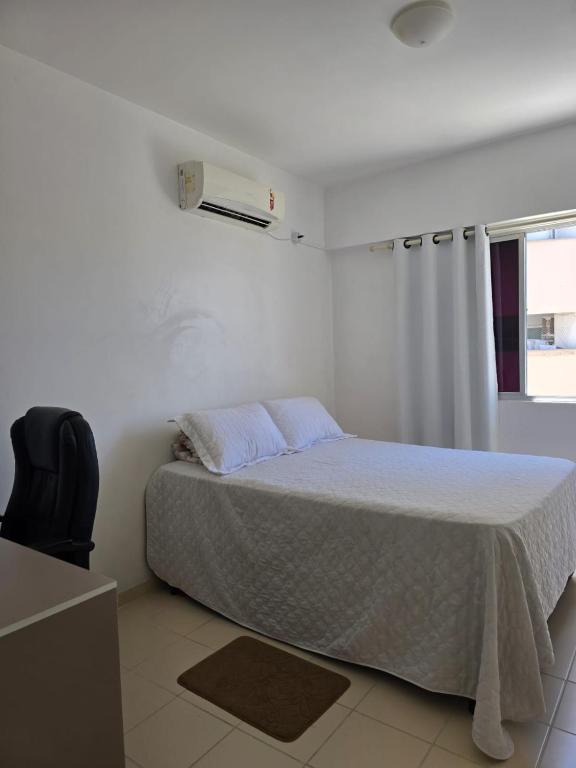 une chambre blanche avec un lit et une fenêtre dans l'établissement Casa Jabuticabeira - Quarto disponivel, à Macapá
