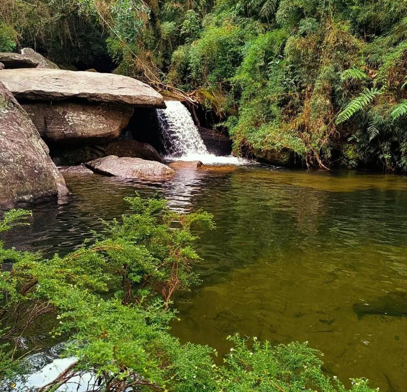 einem Wasserfall in der Mitte eines Flusses in der Unterkunft Casa na Cachoeira das Fadas - Matutu, Aiuruoca - MG in Aiuruoca