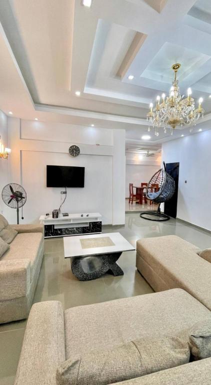 a living room with two couches and a tv at deux chambres et salon chez 198 à Porto Novo in Porto-Novo