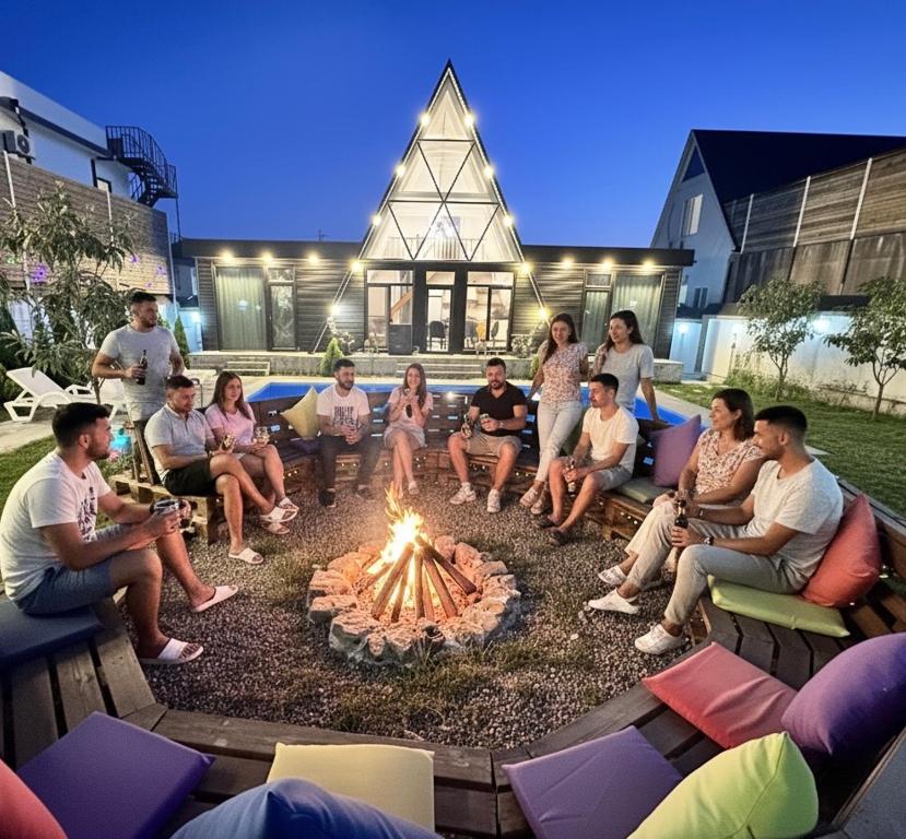 a group of people sitting around a fire pit at Qafqaz Mountside Chalet in Gabala