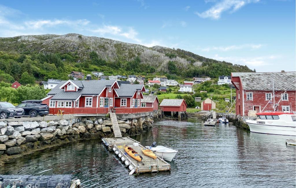 a small town with red houses and boats in the water at Gorgeous Home In Leinøy With House Sea View in Fosnavåg